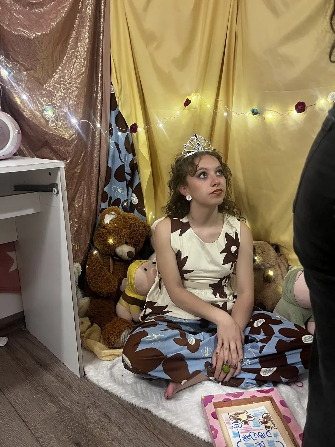 La niña sentada entre los peluches